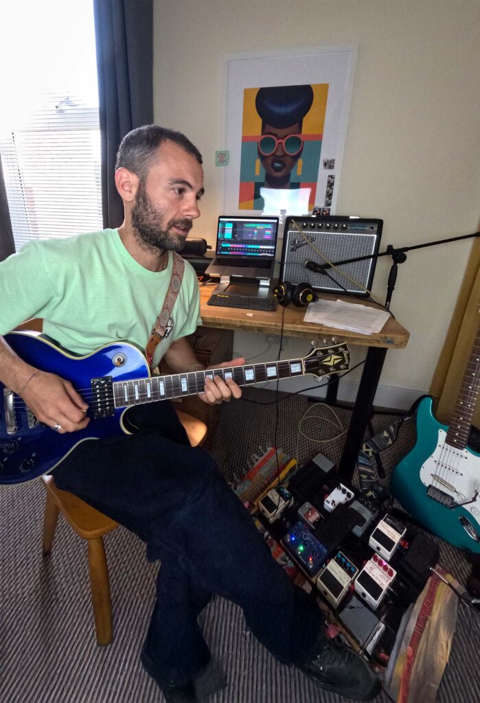 Guitar teacher engaging with student, demonstrating a chord shape